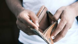 Mann hält leeres Portemonnaie