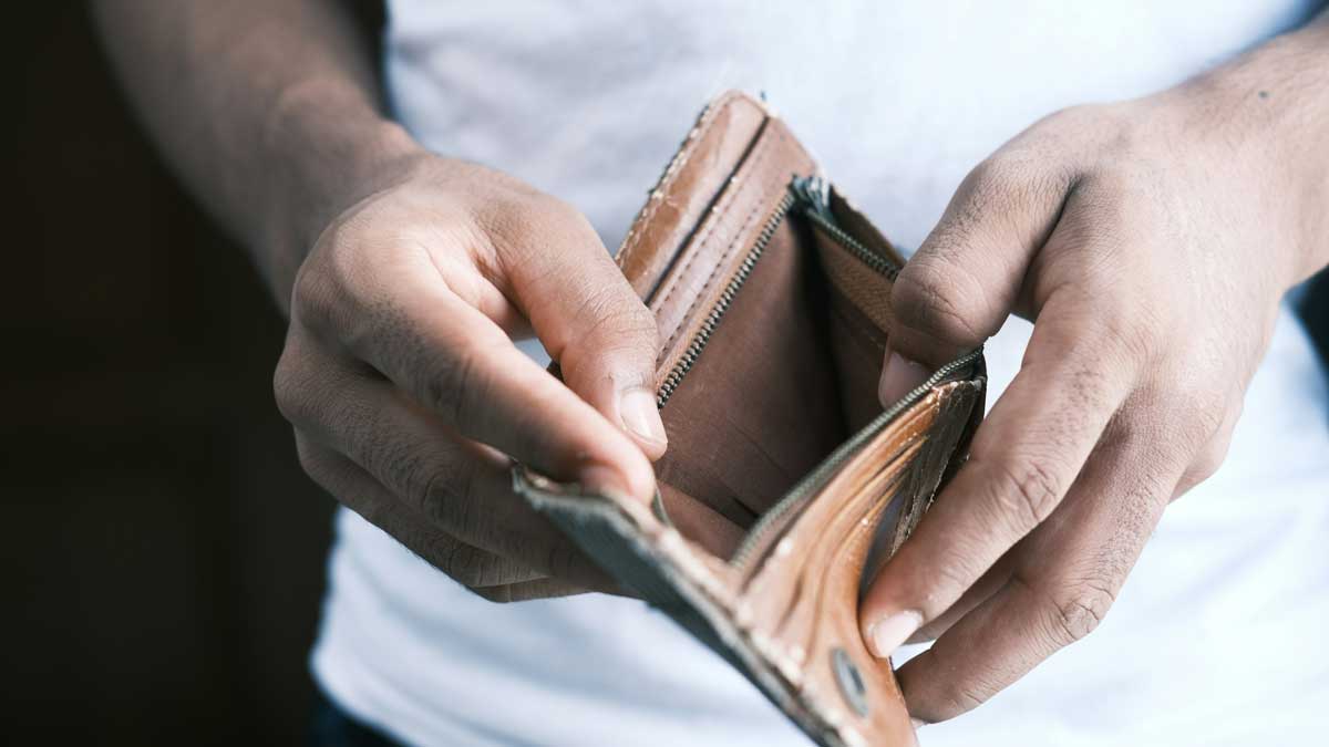 Mann hält leeres Portemonnaie
