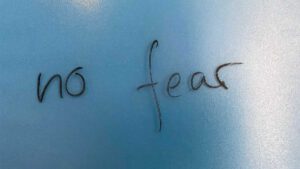 Schriftzug "no fear" mit Marker auf eine Glaswand geschrieben