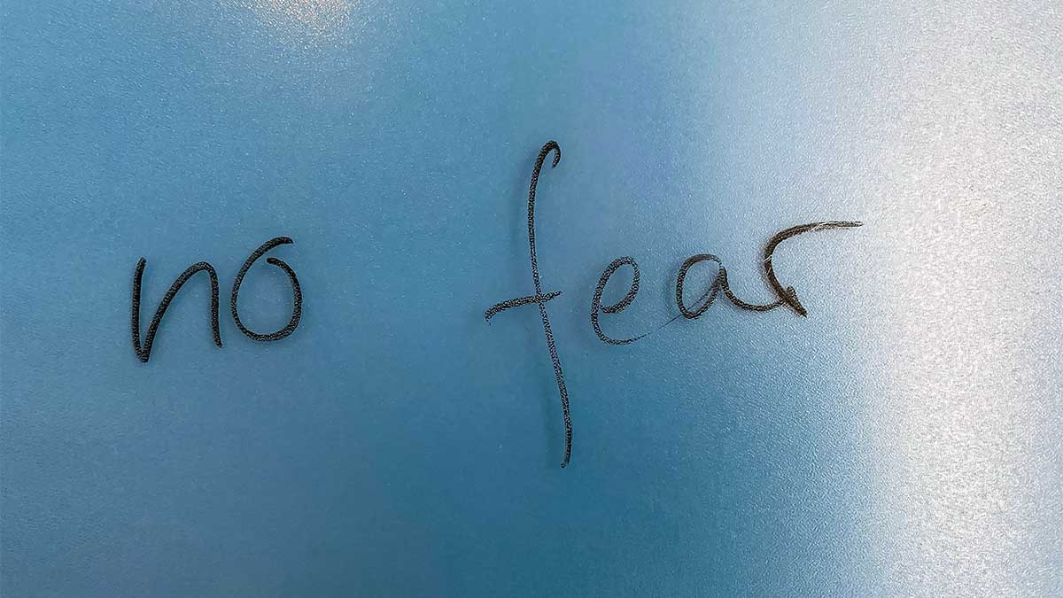 Schriftzug "no fear" mit Marker auf eine Glaswand geschrieben