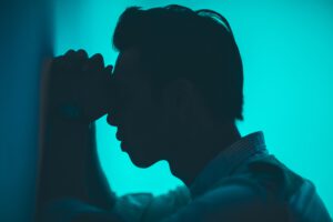 Mann lehnt verzweifelt gegen einer Wand